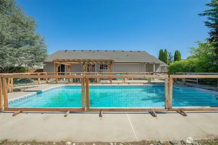 in ground pool features a protective fence to keep littles and animals safe!