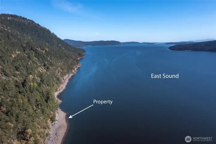 Aerial of beach at low tide and buoy.