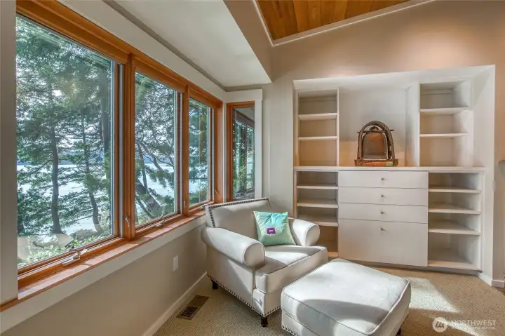 Relaxing sitting area in primary bedroom with built-in shweving.