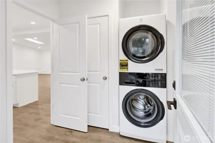 Convenient laundry area with stacked washer and dryer included.