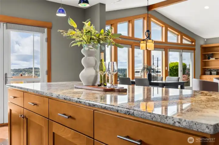Island with custom glass pendant lights open to living area. Perfect for everyday living and entertaining