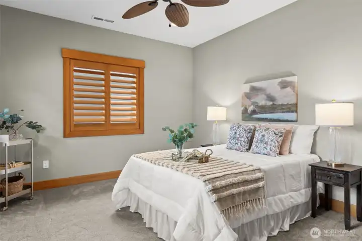 Guest bedroom with large closet and ceiling fan, 3/4 bathroom with tile shower surround nearby