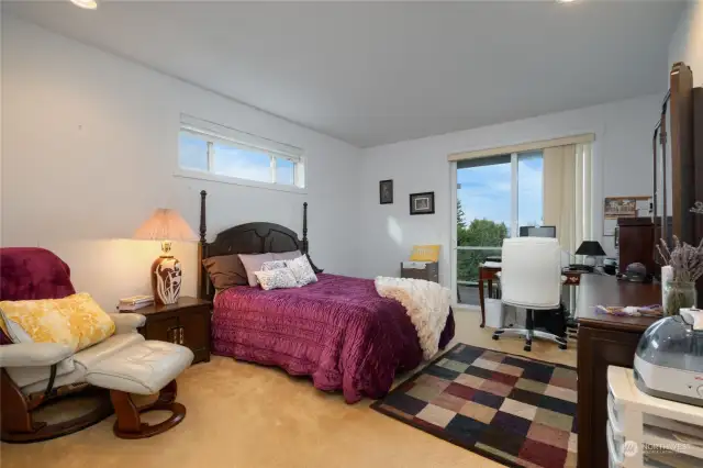 The large primary bedroom has a sliding door leading to the deck