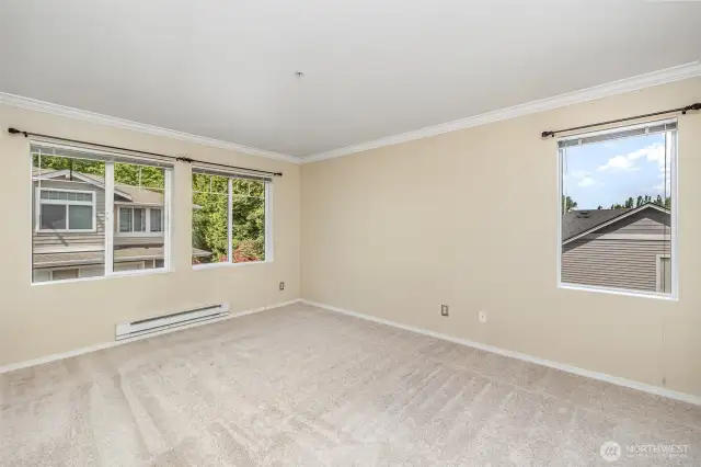 The spacious primary bedroom bathed in natural light, offering a peaceful and refreshing atmosphere to unwind.