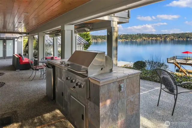 Covered outdoor patio with built in BBQ and refrigerator.