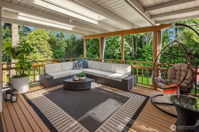 The upper veranda offers a tranquil outdoor space with partial covering and open railings—perfect for lounging with a book, catching up with friends, or simply unwinding above the private backyard.