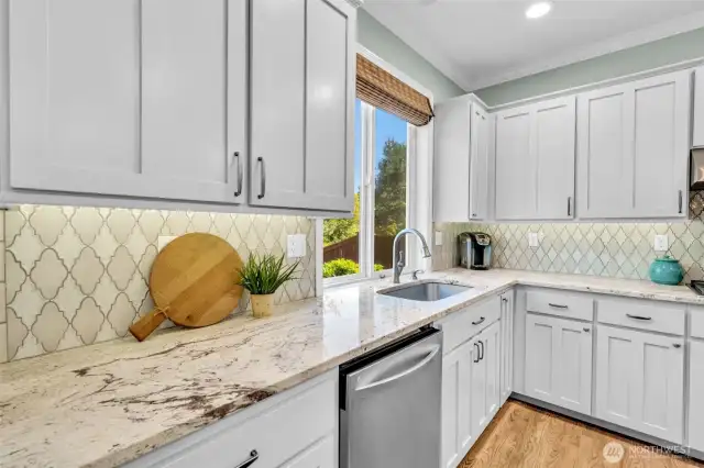 Artisan backsplash compliments the granite counters.