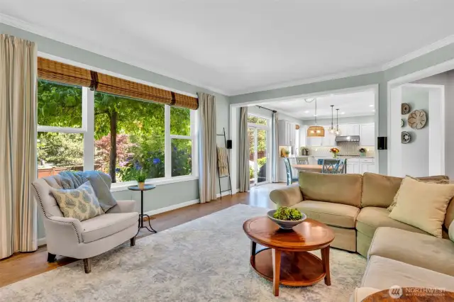 Lovely views of the garden through large windows with custom drapes and blinds.