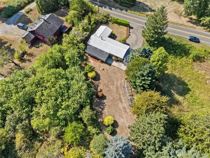 From above, the 1.36-acre corner lot shows its range with wooded areas near the house for privacy, long open backyard space for gardens, and easy access out to Puget Road. It’s land that feels tucked away but still connected.