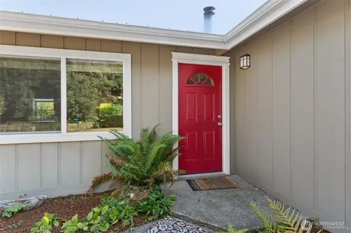 Up close, the front door shows off in red, while a sword fern adds that PNW touch without asking for extra care. The entry is low with no big steps, which means everyone can come and go easily, no drama with stairs or trips.