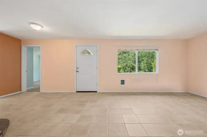 Tile floors in sandstone tones keep this living room durable and easy, and the size makes it functional instead of just filler. Light apricot-butter and amber walls add warmth, while the big picture window makes the room feel even larger. A cadet wall heater gives you custom heat on demand, and the front door’s arched glass detail adds some charm. The best part? The largest bedroom opens right here, so no one has to wander down a hallway to find it.