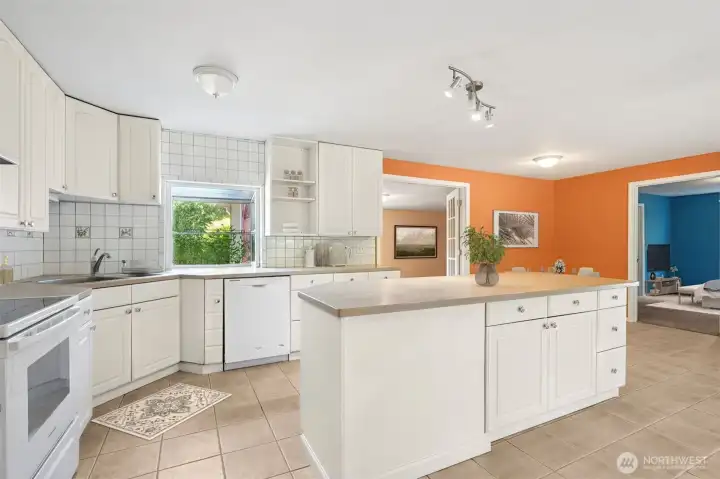 Square white tile is a classic move, but here it’s done right, running floor-to-ceiling so the kitchen feels finished. The glass-topped electric stove adds to the clean lines, and you skip the natural gas debate entirely. It’s simple, safe, and polished.