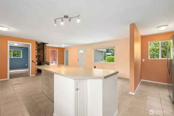 The island gets practical with a rotating corner cabinet and bar seating that faces the living room, not the stove. It makes conversation easy, whether you’re hosting or just trying to keep an eye on things. The side wall is finished in tile to handle scuffed shoes from stools, proving durability can still look polished.
