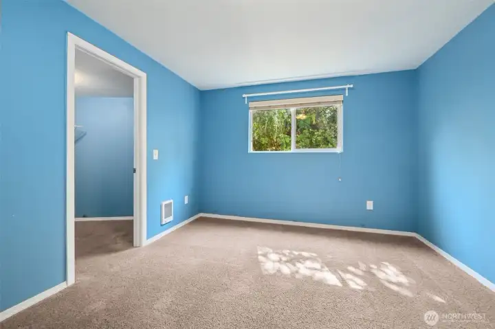 Sky blue and baby blue walls give this smaller bedroom some personality, while dark latte carpet grounds it. The walk-in closet is the surprise here, turning the “smallest room” into one that actually pulls its weight. Ideal for a guest space, craft room, or a dedicated Zoom zone.