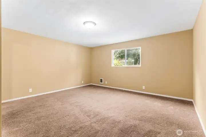 At roughly 15'x15', this bedroom gives you real square footage to work with. Mirrored closet doors double as full-length fit check central or your own dance studio. The tan walls keep it light, while warm latte carpeting makes the room feel grounded.