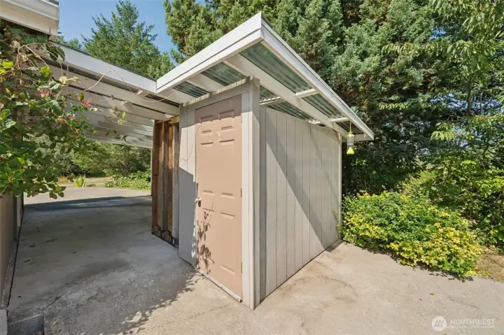 The garden shed brings in natural light with a clear roof section, making it easy to use as more than just storage. Its roof stretches to the side of the house, doubling as a carport that keeps your vehicle dry and out of the weather. Practical, simple, and a nice win for everyday life.