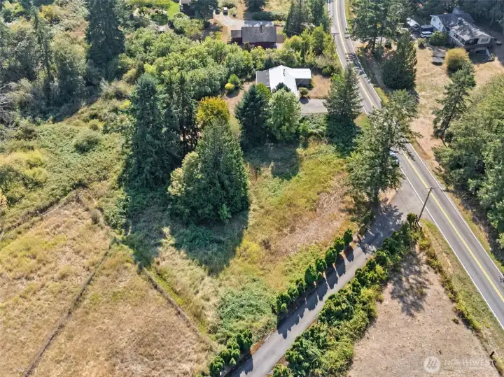 From above, you see how the property stretches from the home’s front approach to the acre of pasture just behind the mature treed area. Puget Road lines the front, so you get convenient access without losing the country vibe that comes with this much space.
