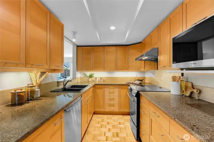 Kitchen with parquet floors, stainless steel appliances, and eating area.