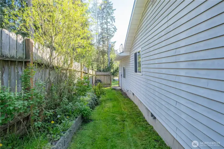 Side of home with the gate to the driveway