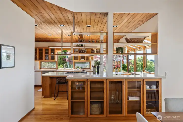 Custom built-ins and open shelving separate dining room and kitchen