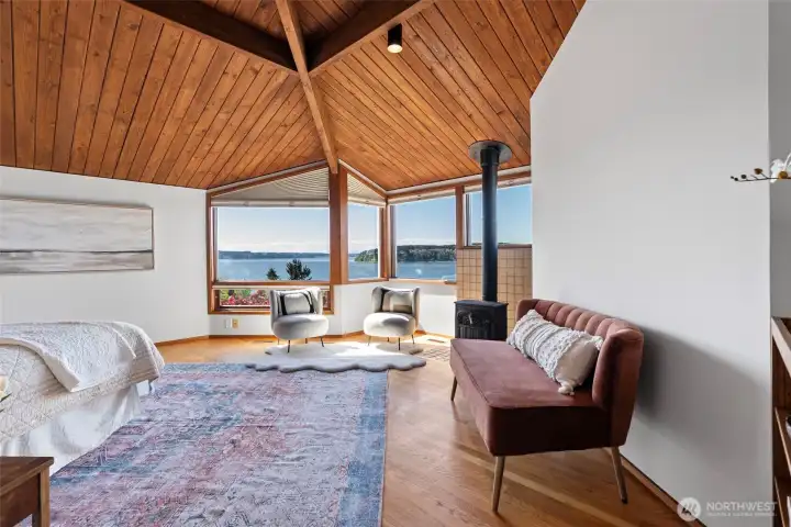 Primary bedroom with vaulted ceiling and wood burning stove