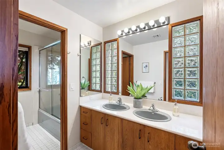 Upstairs bathroom with dual sink vanity and shower/tub combo