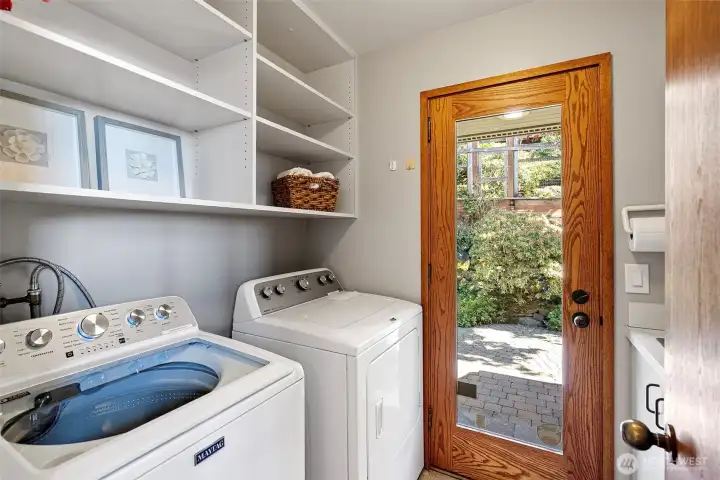 Upstairs laundry room with door to back patio and gardens