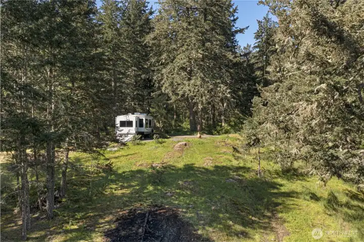 Prepared RV site nestled among the trees offers a comfortable basecamp while designing and building your future island residence.