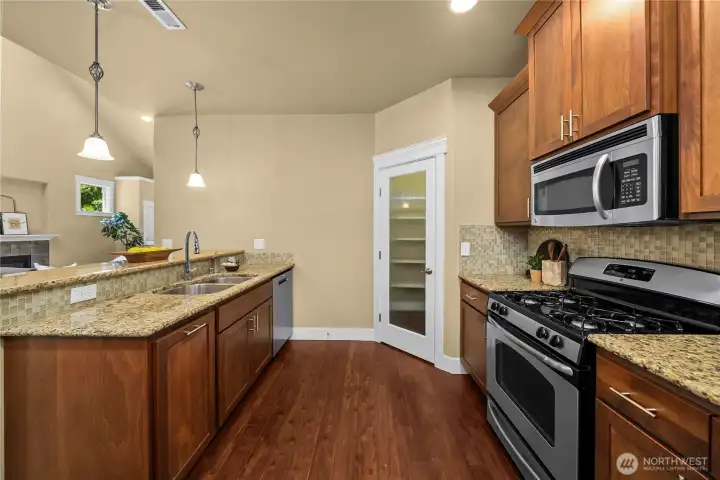 This upgraded kitchen is appointed with granite counters, cherry cabinetry with crown molding, full-height tile backsplash, stainless steel appliances and a spacious walk-in pantry. This upgraded kitchen is appointed with granite counters, cherry cabinetry with crown molding, full-height tile backsplash, stainless steel appliances and a spacious walk-in pantry.