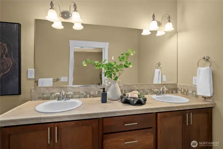 The primary bathroom offers a tiled, dual-sink vanity and a large walk-in shower The primary bathroom offers a tiled, dual-sink vanity and a large walk-in shower
