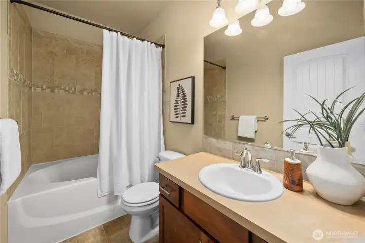A full bath on the upper level features a shower-tub combo with full tile backsplash. A full bath on the upper level features a shower-tub combo with full tile backsplash.