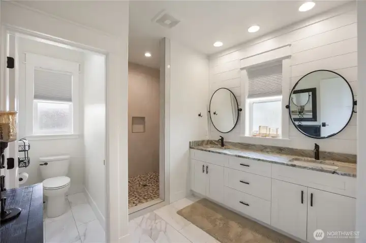 Primary Bath with double vanities, leather wrapped quartzite, porcelain floors