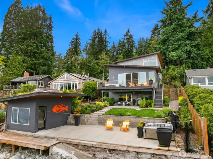 Looking from the water to the home. Boat house is on the left, hot tub on the right. Beautiful gardens and patio spaces.