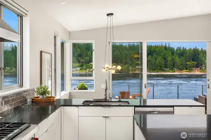 The kitchen has two sinks, this one overlooking the water. Bosch dishwasher, Viking Range and oven and SubZero fridge. There is a full freezer in the pantry. Quartz countertops and streamlined cabinetry finish the space.