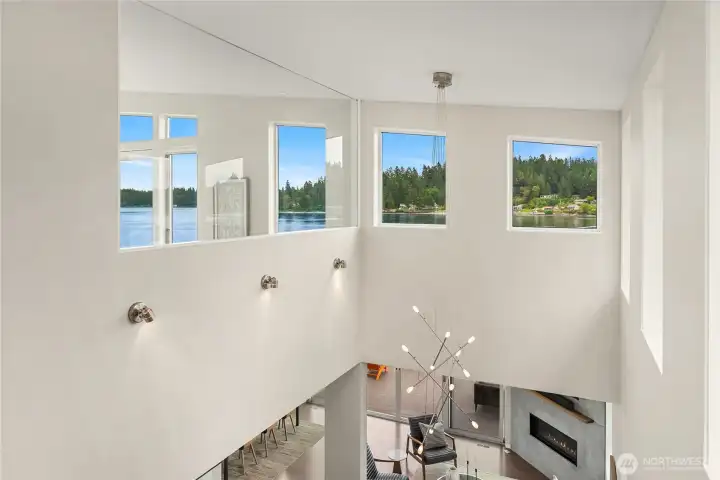From the upper level landing looking out over the windows to the water.
