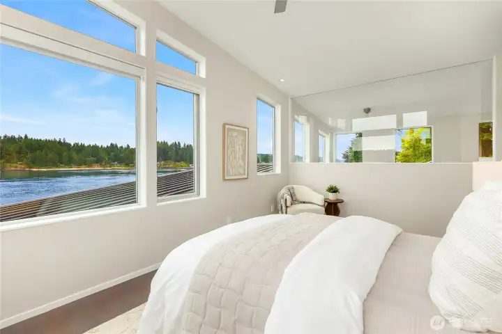 The glass wall in the primary allows light and views in on three sides of the primary suite.