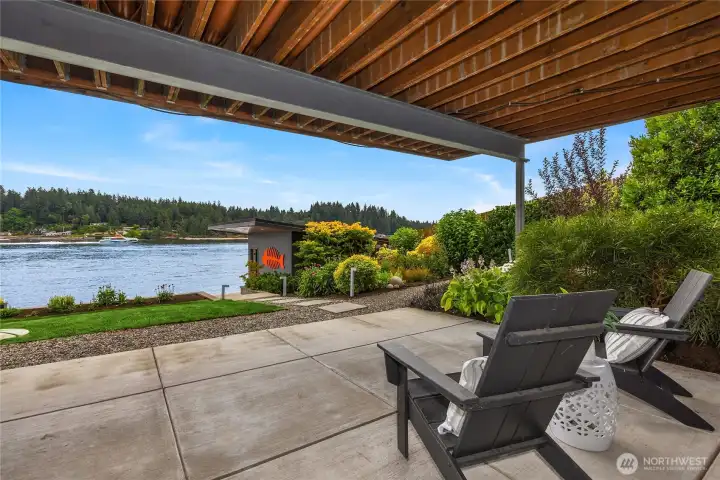 The lower level opens to a covered patio and is steps to the hot tub and boat house.