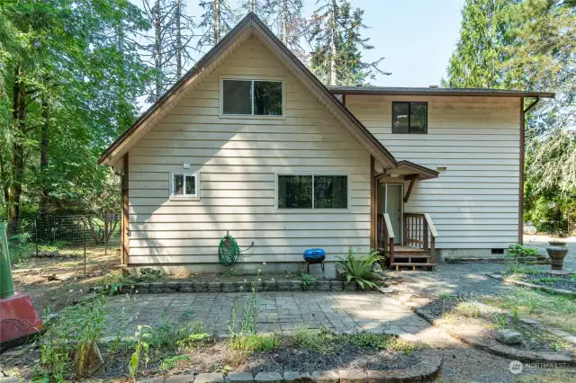 Paver patio with flower beds. Fenced deer proof garden or dog yard shown at left.