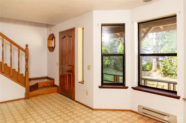 Kitchen eating area showing front door and stairs to primary bedroom loft.