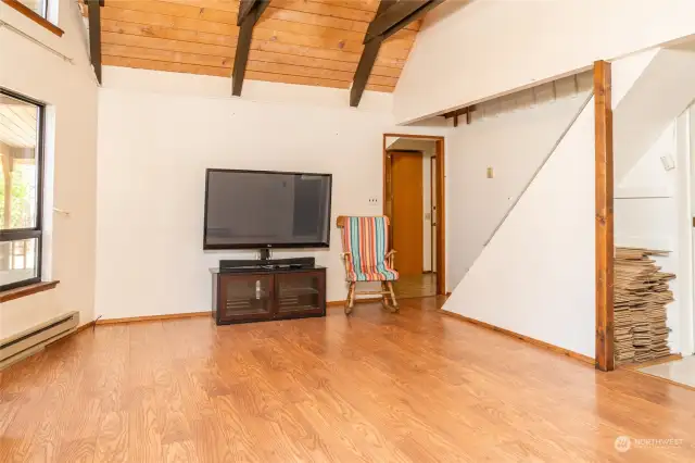 Living room looking towards kitchen. Loft stairs on camera right.