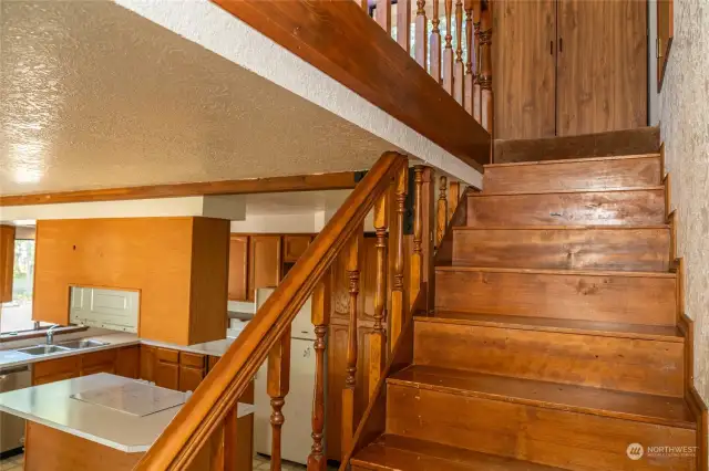 Stairs to primary bedroom loft, showing kitchen on left.