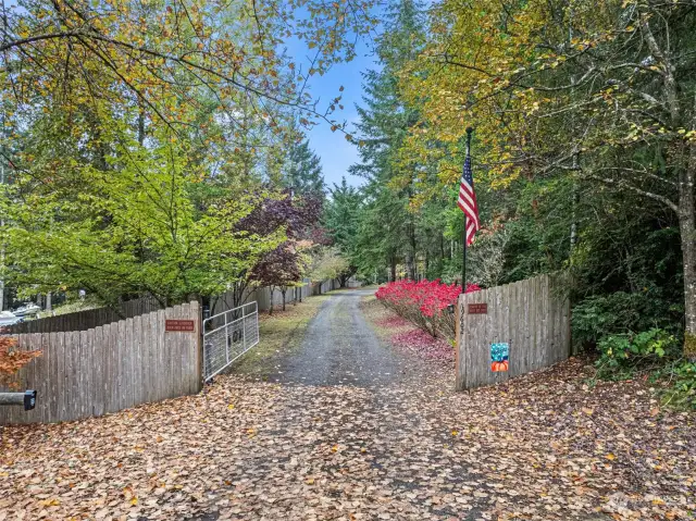 Electronic gate with keypad & remote greets you as you arrive at this amazing property.  Drive is lined with mature landscaping for year round color.