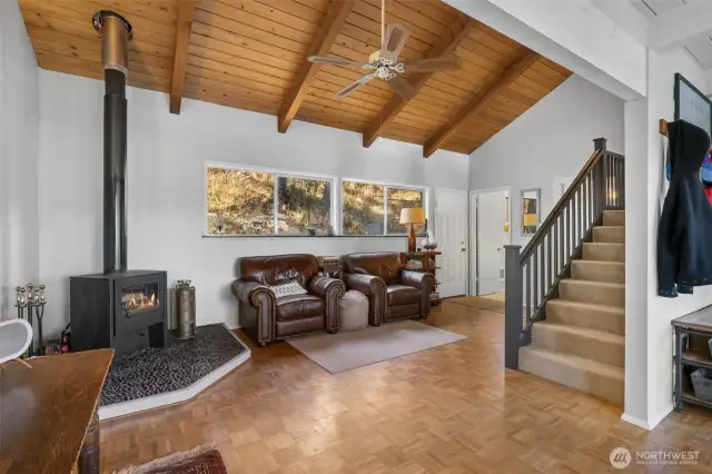 Living room is full of natural light and warmth with newer wood fireplace and vaulted ceilings.