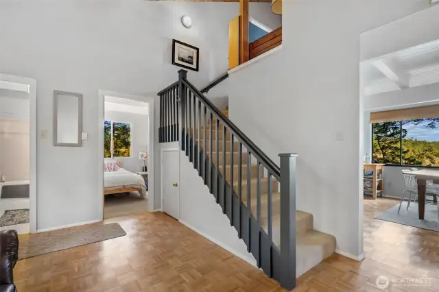 Vaulted ceilings in living room with large staircase leading up to upstairs landing, primary bedroom and bonus room.