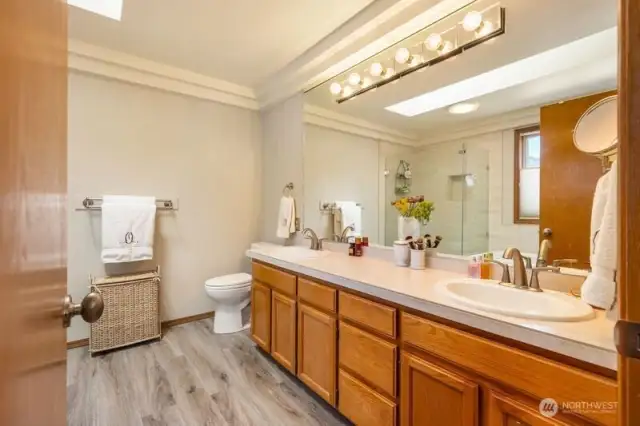 Primary 5 piece bath that was recently remodeled with new flooring, tile and frame less shower surround.