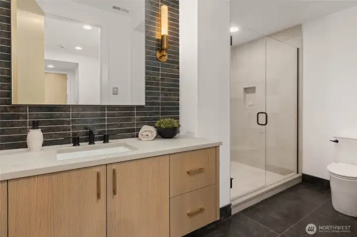 Lower lever 3/4 bath off rec room with mud set tile shower and designer heated stone floors