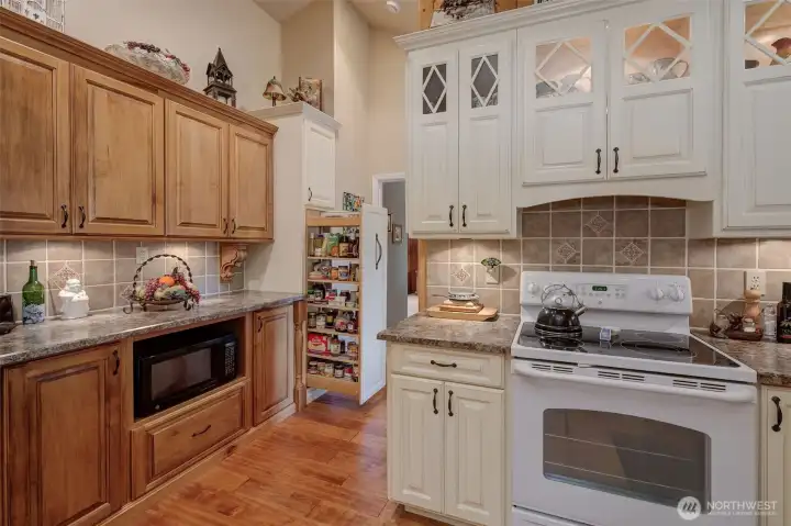 Spacious kitchen thoughtfully designed for maximum efficiency and functionality! Notice the cabinet lighting and pulled-out spice rack for your viewing...
