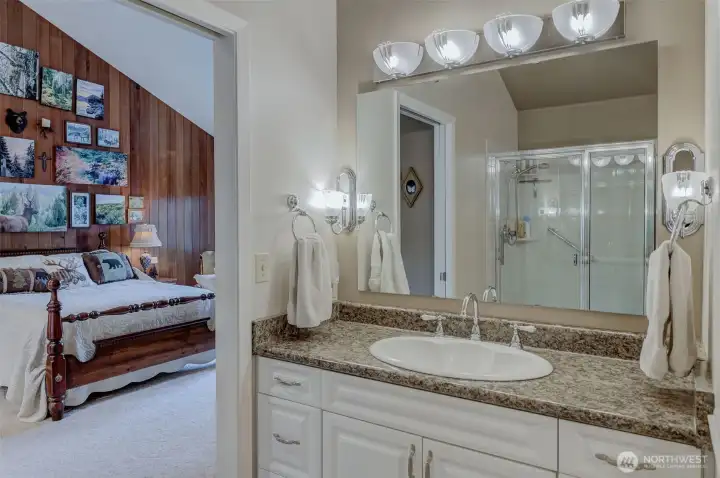 Vanity in primary bath, looking toward feature wall in primary suite