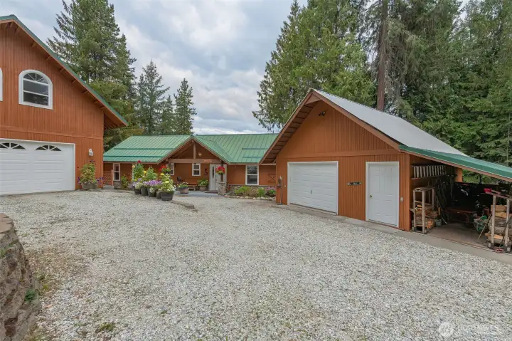 Two-story garage on left, home in center, workshop (previously snowmobile garage) on right.