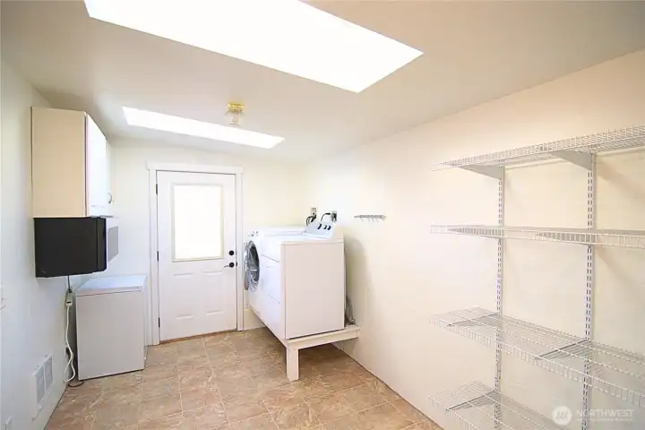 Laundry/ mud room with raised appliances for easy usage.